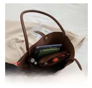 Macro view of large brown tote bag interior showing spacious capacity for tablets and cosmetics