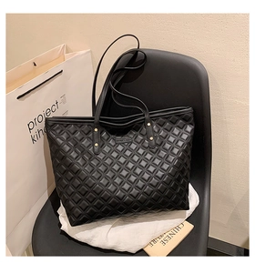 Détails du sac cabas matelassé noir avec rivets dorés et fines anses pour le bureau