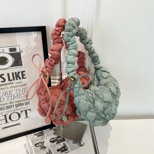 Détail de la texture matelassée bulle et de la bandoulière froncée sur sacs rose et vert