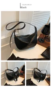 Detail of black pleated hobo bag showing quilted texture and gold metal zipper hardware
