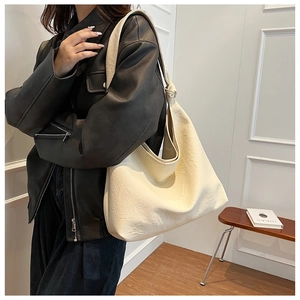 Detail of soft cream hobo bag with unique knotted strap and pleated leather texture