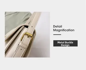 Gros plan sur la boucle dorée et la bandoulière en cuir beige du sac à main mode