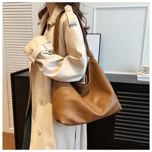 Brown large capacity hobo bag with vintage soft leather texture on a beige coat outfit