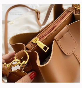 Gros plan détaillé du sac bandoulière en cuir marron avec finitions dorées élégantes