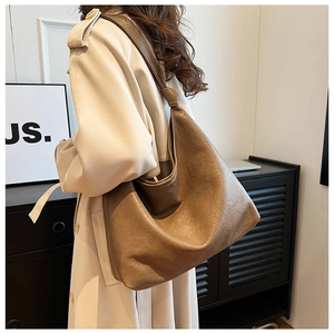 Detailed texture of the soft khaki faux leather and shoulder strap on the bucket bag