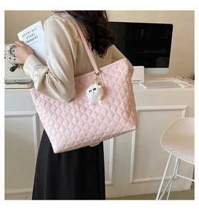 Détail du cabas matelassé rose avec pendentif chat dans un décor de bureau