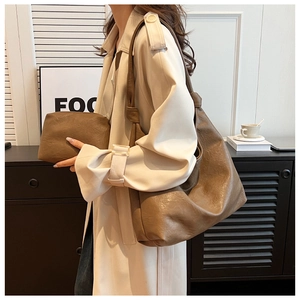 Detail view of brown pebbled leather tote bag and matching pouch for daily commute