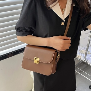 Détail d'un sac à bandoulière en cuir marron avec boucle carrée en métal doré