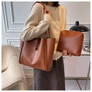 Caramel brown tote bag set with inner pouch shown in a modern minimalist interior setting