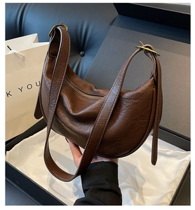 Close-up of vintage brown hobo bag with leather texture in a luxury gift box
