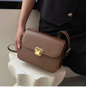 Vue détaillée d'un sac bandoulière en cuir marron avec un fermoir doré carré vintage