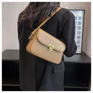 Détail du sac bandoulière en similicuir kaki avec fermoir métallique carré sur modèle