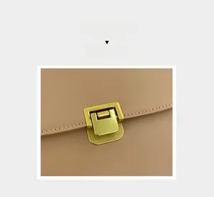 Dettaglio borsa in pelle beige chiaro con fibbia in metallo dorato e cuciture curate