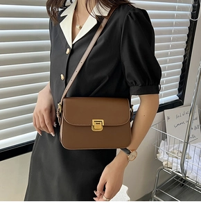 Détail du sac bandoulière en cuir marron avec boucle dorée et bandoulière réglable