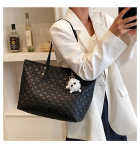 Détail du sac cabas matelassé noir avec breloque mouton blanc et bandoulière
