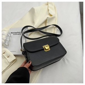 Détail d'un sac à main minimaliste en similicuir noir avec un fermoir doré carré élégant