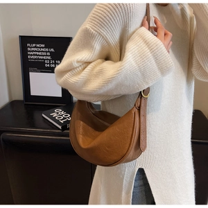 Brown vintage hobo bag with pleated leather texture shown on shoulder for capacity