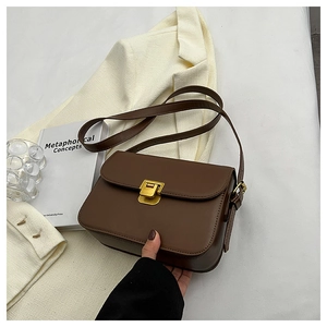 Détail d'un sac bandoulière marron minimaliste avec élégant fermoir rectangulaire doré