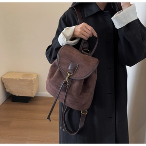 Side view of dark brown frosted leather backpack with drawstring closure and gold hook