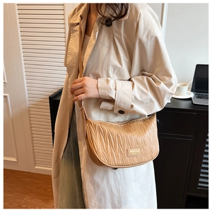 Detail of khaki pleated hobo bag with adjustable strap and gold metal logo plaque