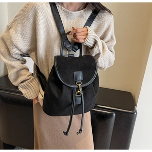 Detail of vintage matte black backpack with suede texture and gold hook buckle