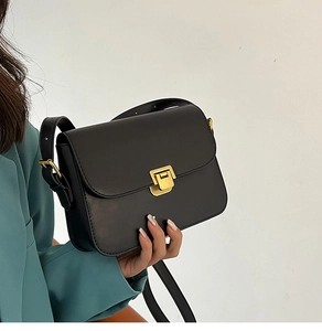 Détail du sac à bandoulière en cuir noir vintage avec fermoir à poussoir carré doré brossé