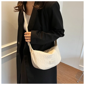 Detail of ivory hobo bag with pleated texture and metal logo on black blazer
