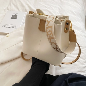 Sac seau chic crème et marron avec deux bandoulières sur fond blanc élégant