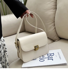 Détail du sac bandoulière blanc crème en cuir avec fermoir rotatif doré vintage