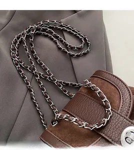 Close-up of brown leather and suede crossbody bag with silver chain and metal clasp