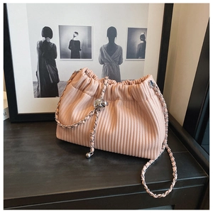 Detail of pink pleated cloud bag featuring a silver chain and large metallic sphere