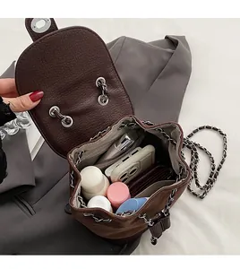 Interior view showing the large capacity of the brown leather bucket backpack with daily items