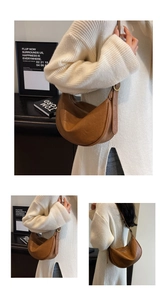 Detail of retro brown crescent bag showing adjustable strap and smooth faux leather texture