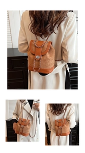Detail of tan bucket bag with metal twist lock and chain strap on female model