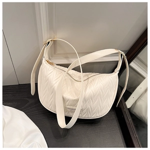 Detail of white pleated crescent bag featuring golden hardware and leather texture