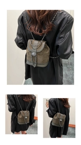 Detail of dark green suede and textured leather backpack with silver chain and lock