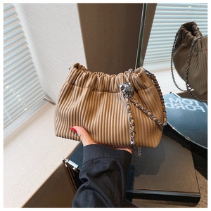 Detail of khaki pleated bucket bag with silver chain and metal knot ball decoration