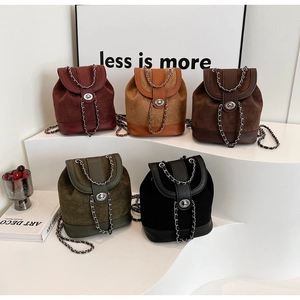 Close-up of five mini drawstring backpacks with metal chains in assorted colors