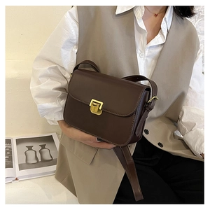 Dettaglio di una borsa a tracolla vintage in pelle PU marrone con fibbia in metallo dorato