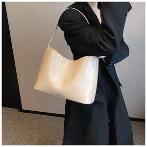 Close-up of cream leather shoulder bag with sleek V-shaped opening and refined texture