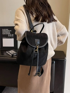 Vintage matte black drawstring backpack with metal buckle closure worn by a model