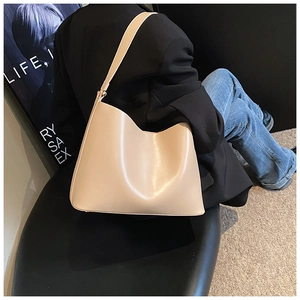 Chic beige faux leather shoulder bag shown on model in a modern lifestyle setting