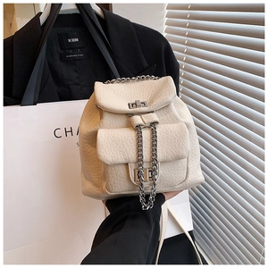Close-up of off-white lychee leather mini backpack with silver chain and dual push-locks