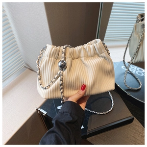 Close-up of white pleated bucket bag with silver chain strap and metallic ball detail
