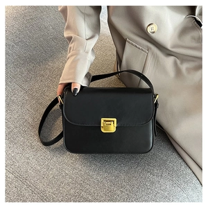 Dettaglio di una borsa a tracolla nera chic con fibbia dorata e texture opaca