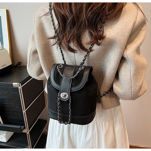 Detail of matte suede mini backpack with woven silver chain strap and metal turn-lock closure