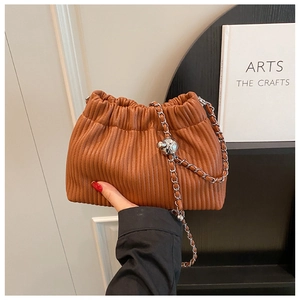 Detail of brown pleated bucket bag with silver chain strap and metal ball clasp decoration