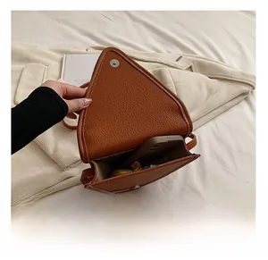 Sac bandoulière en cuir marron montrant la capacité intérieure pour téléphone et maquillage