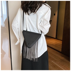 Détail du sac bandoulière triangulaire noir en cuir avec de longues franges grises