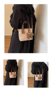 Detail view of mini tote bag with vintage wash texture and brown puppy pendant